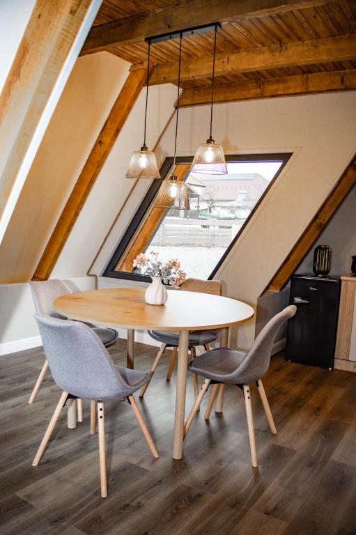 Interiorul cabanei cu masă de dining și fereastră triunghiulară